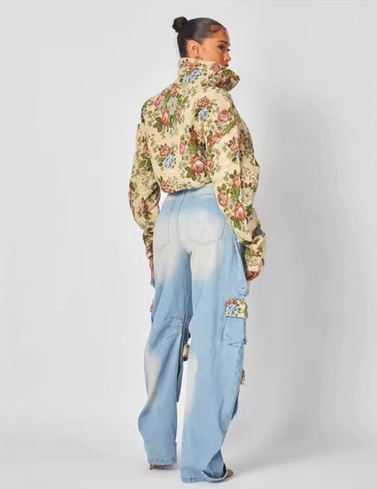 Person wearing a floral jacket and light blue pants on a white background