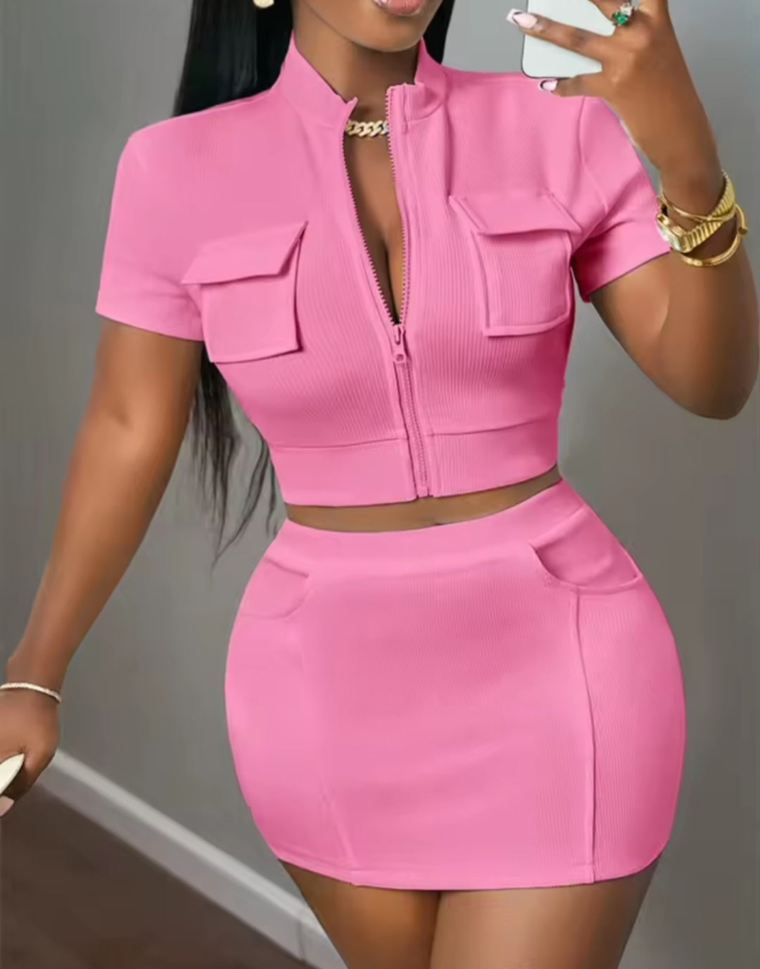 Woman wearing a pink outfit with a matching skirt and top.