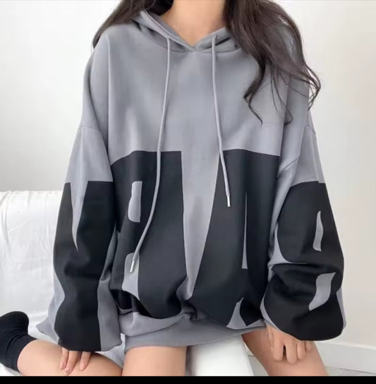 Person wearing a gray and black hoodie with a white background