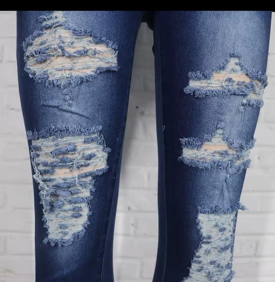 Ripped blue jeans on a white brick wall background