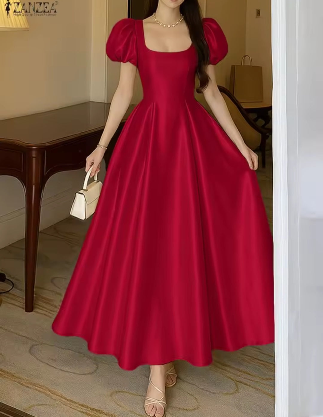Woman wearing a red dress with puff sleeves in an indoor setting