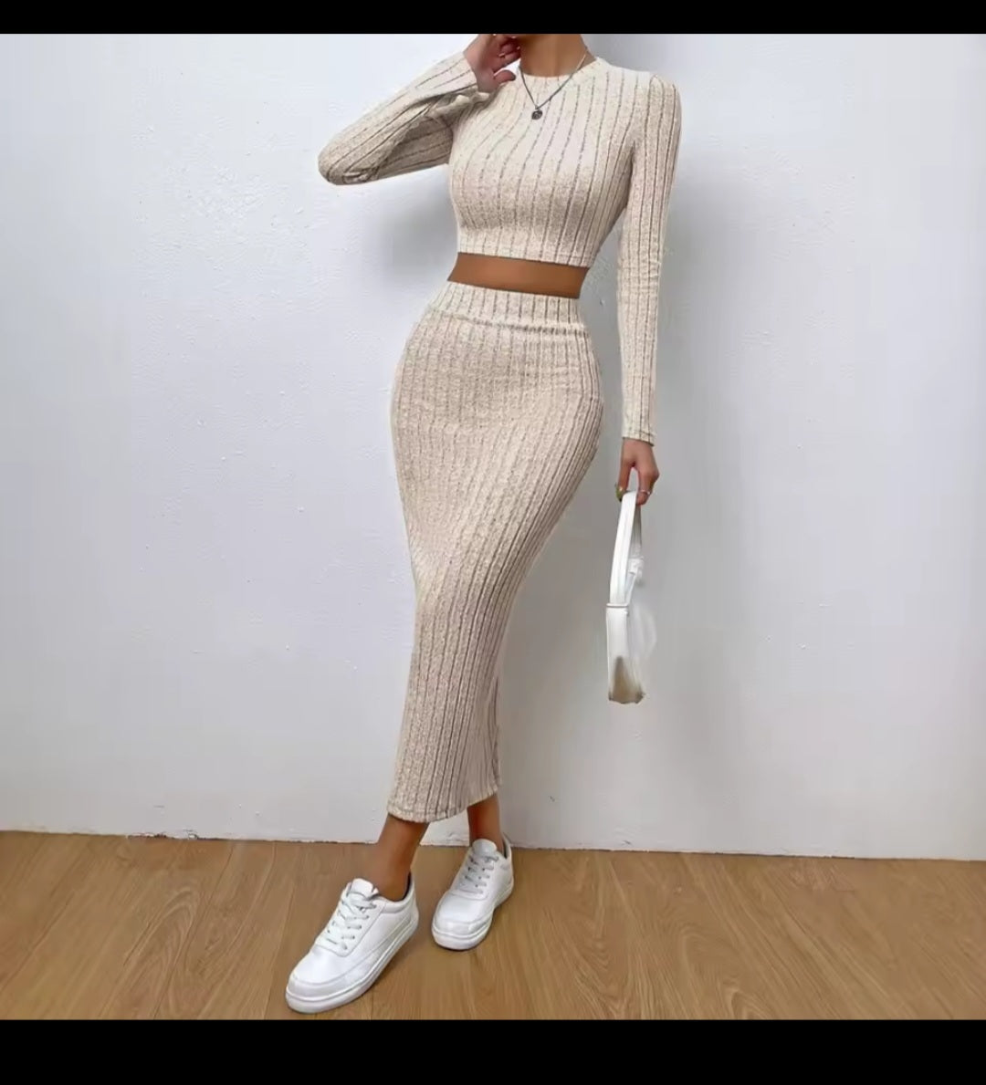 Person wearing a beige ribbed two-piece outfit with white sneakers on a plain background