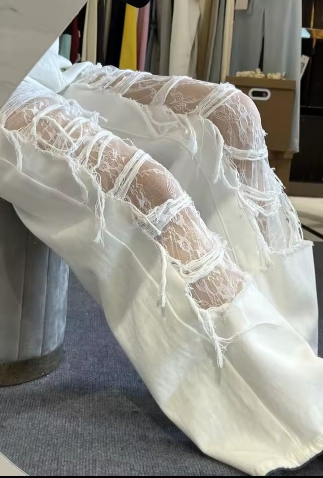 White lace-trimmed pants on a mannequin in a store setting