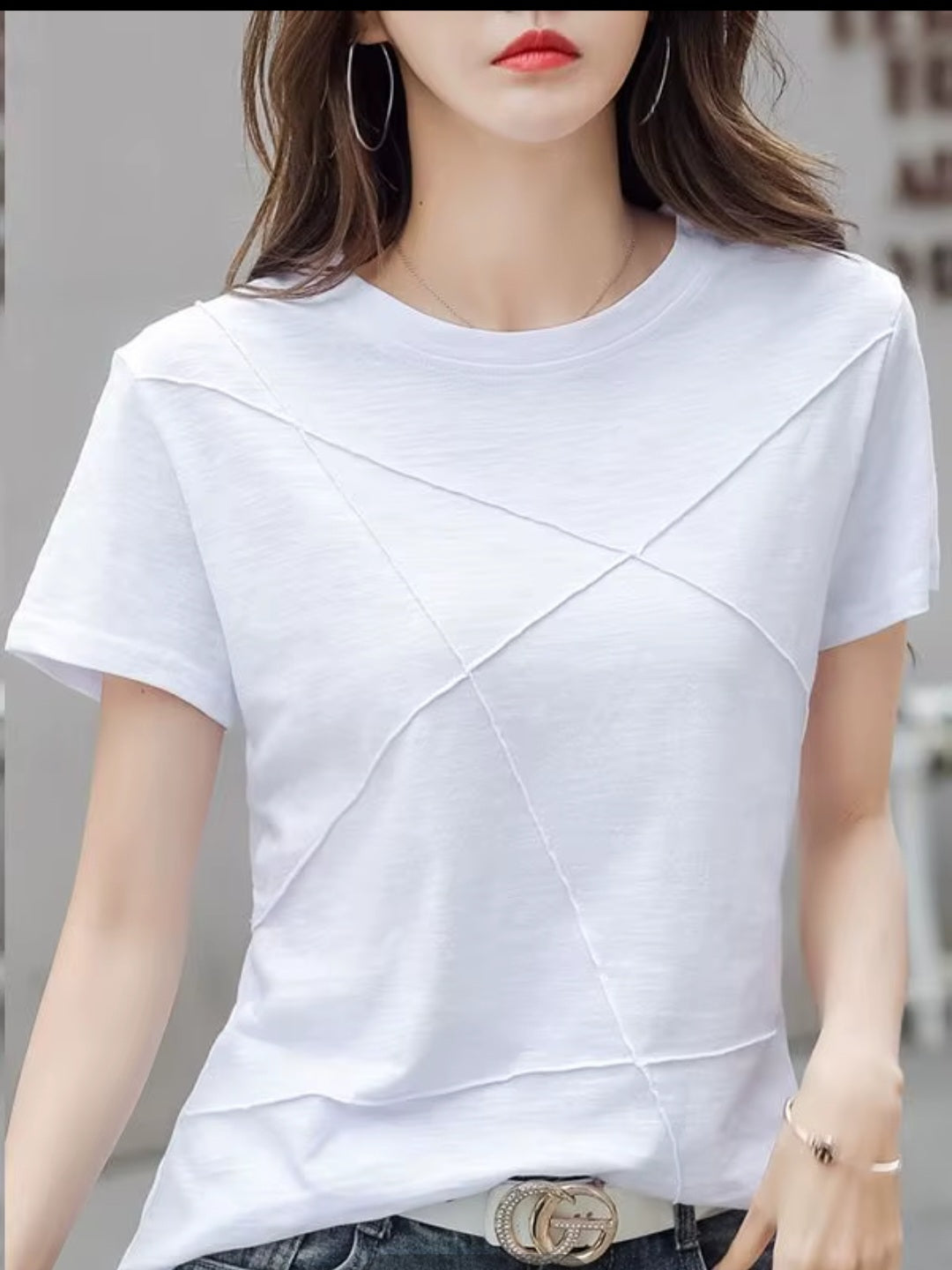 White t-shirt worn by a person with a blurred background