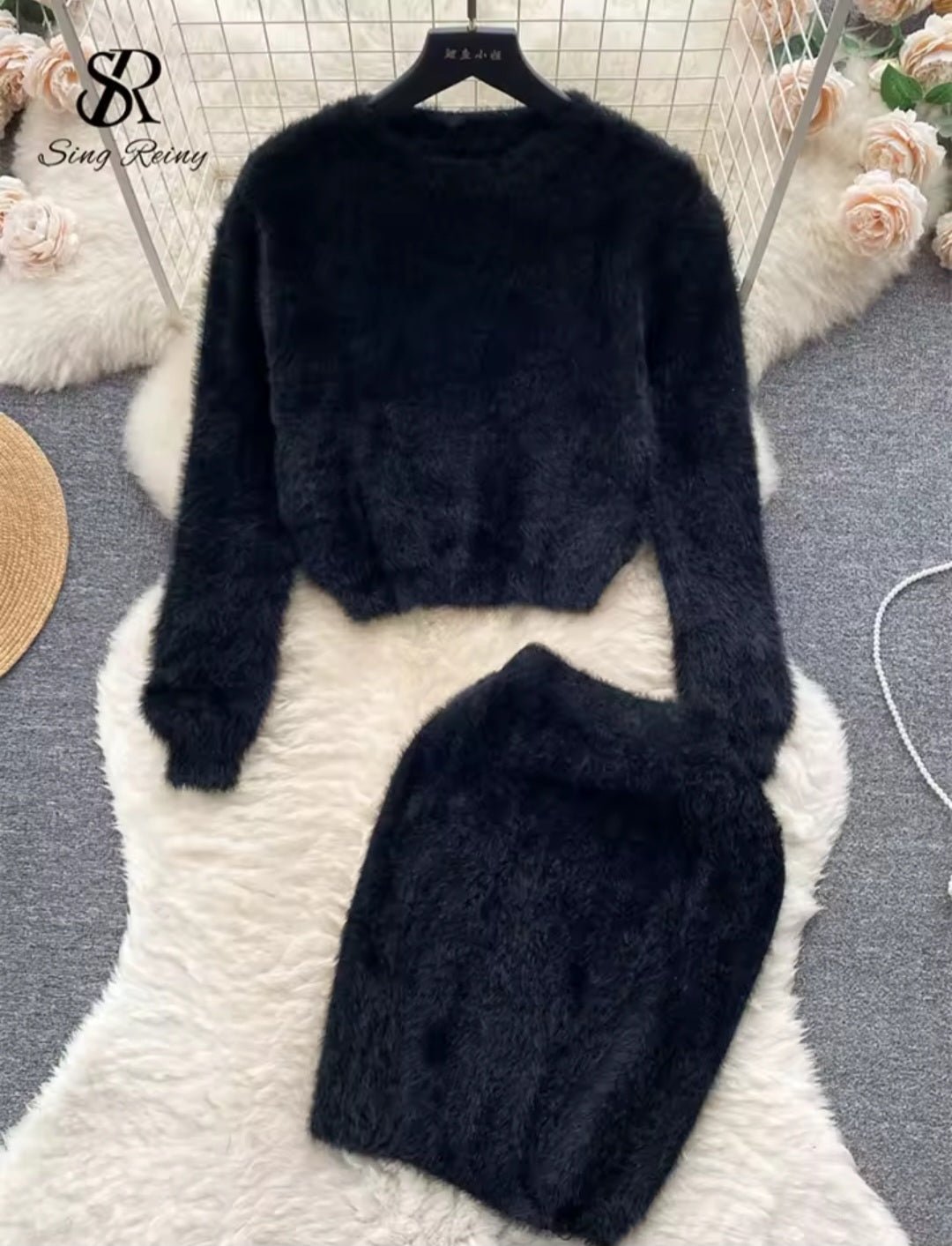 Black sweater and skirt set on a hanger with floral decorations in the background