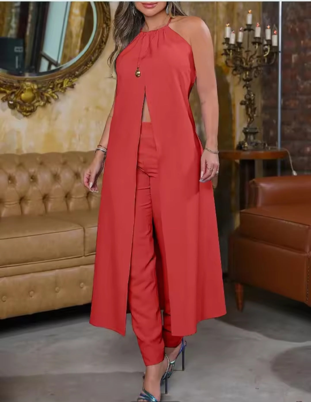 Woman in a red outfit standing in a room with brown leather furniture.