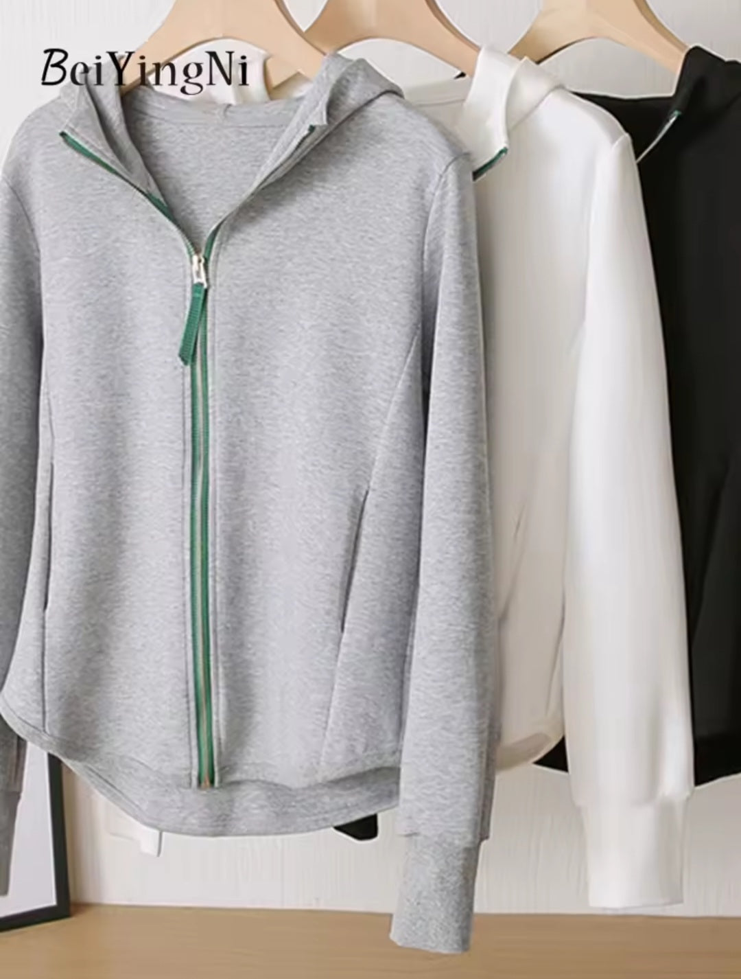Gray zip-up hoodie on a hanger with 'BeiYingNi' branding.