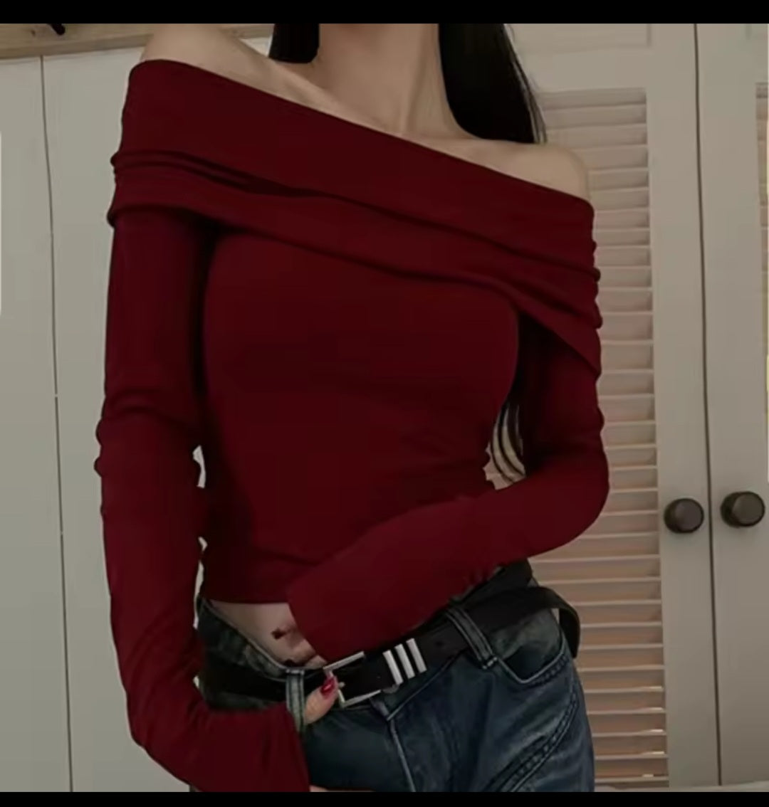 Person wearing a red off-shoulder top and jeans indoors.
