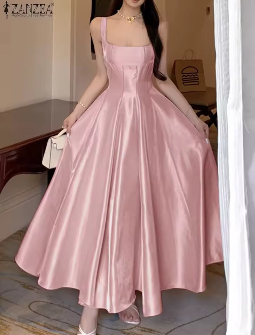 Woman wearing a pink satin dress in an indoor setting