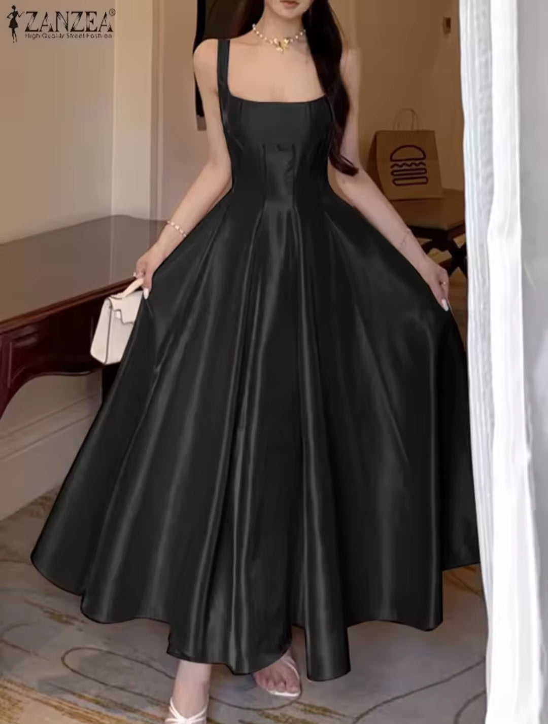 Woman wearing a black satin dress with a plain background