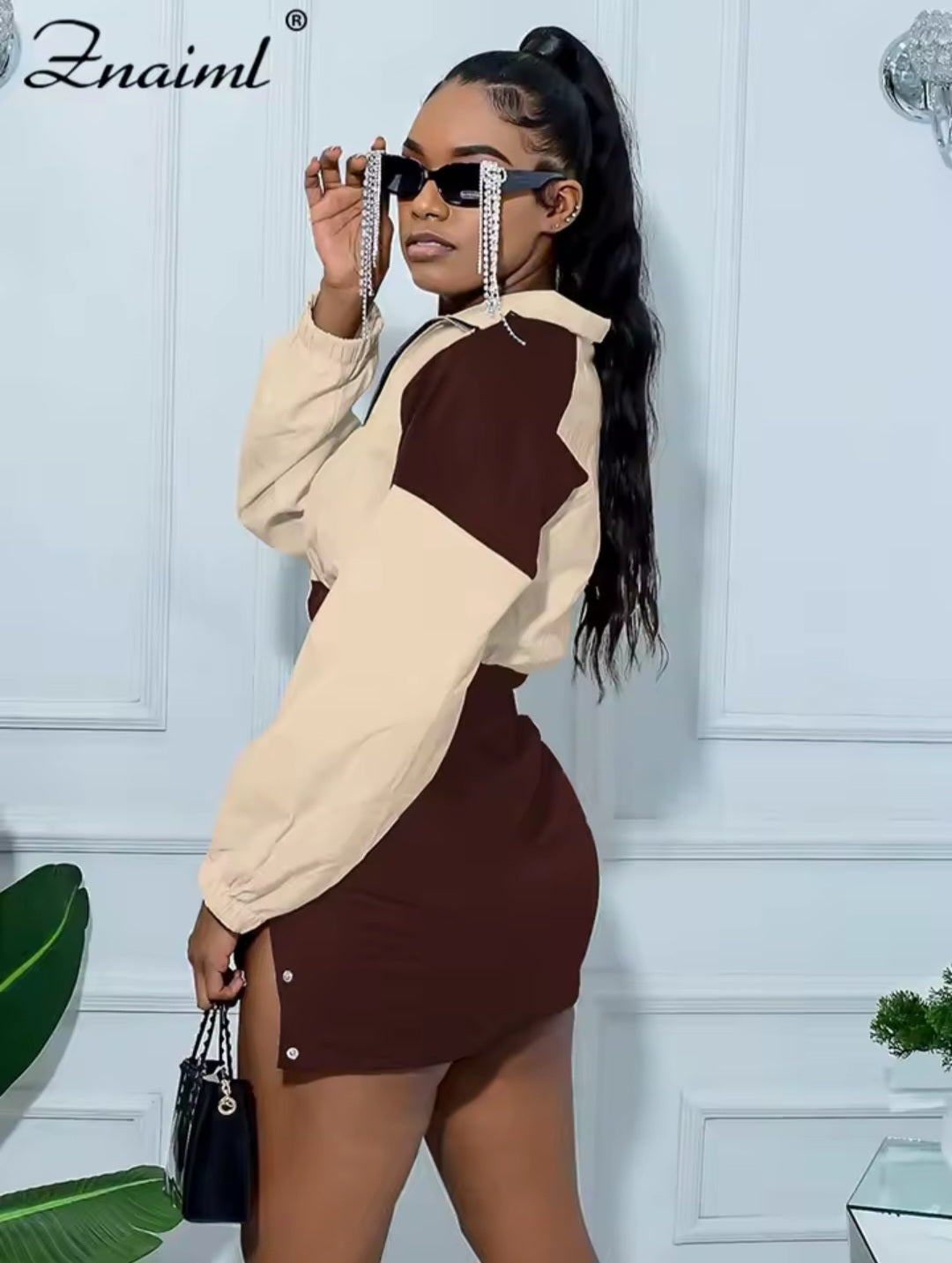 Woman wearing a beige and brown outfit with sunglasses in an elegant interior setting
