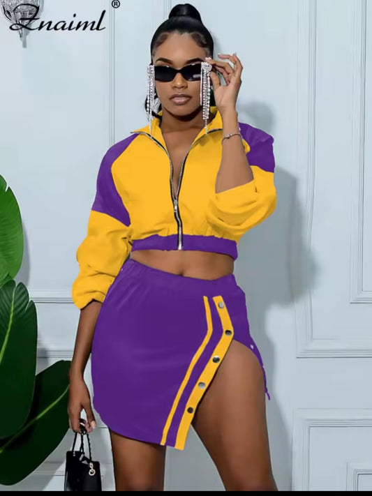 Woman wearing a yellow and purple outfit with a plant and white wall background