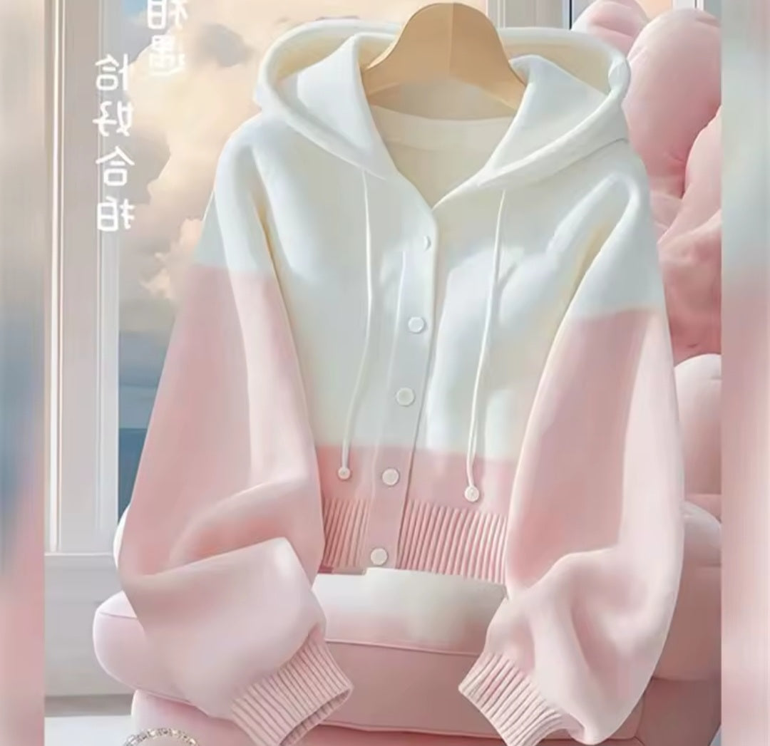 White and pink gradient hoodie on a hanger with a blurred background