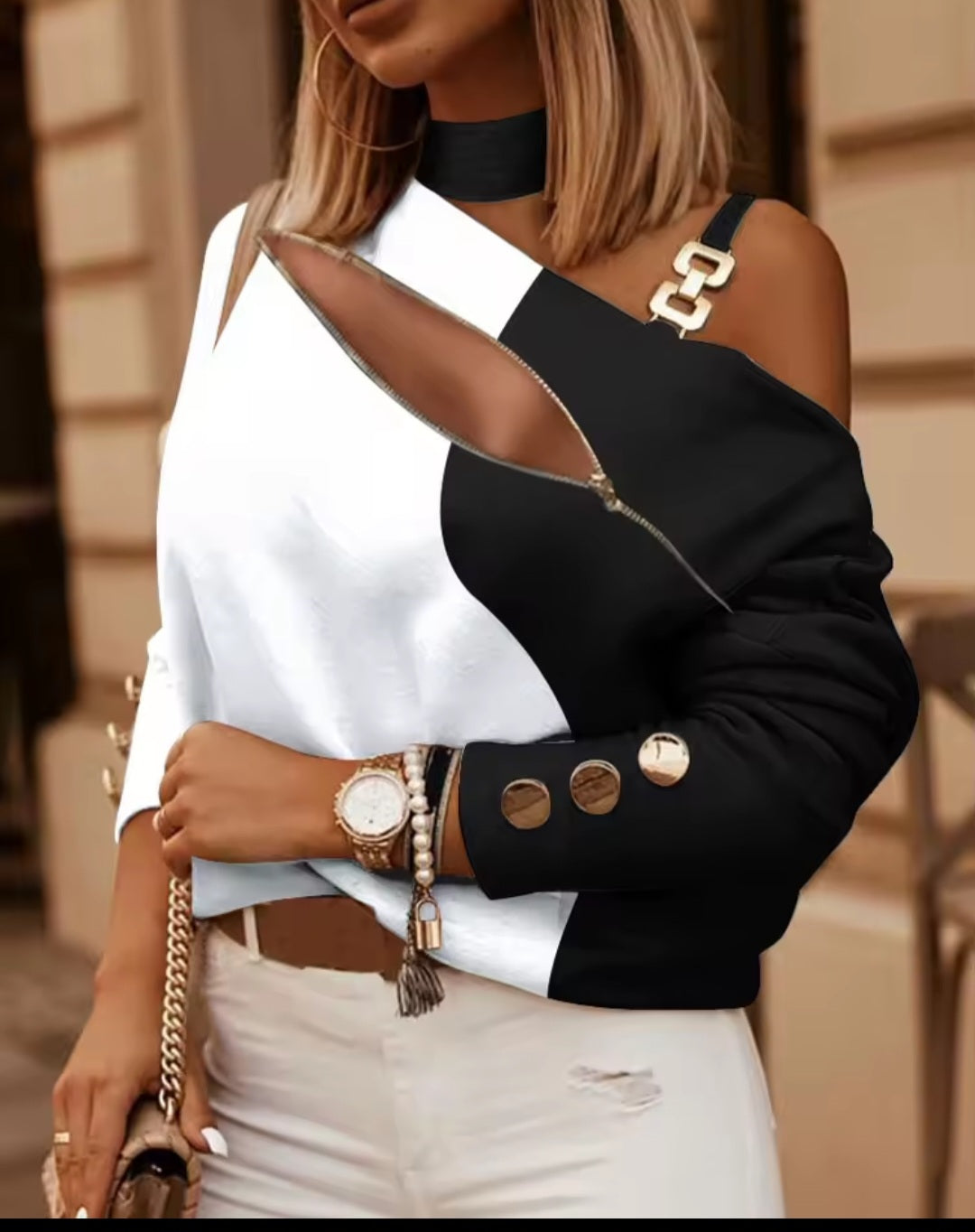 Person wearing a black and white outfit with gold accents
