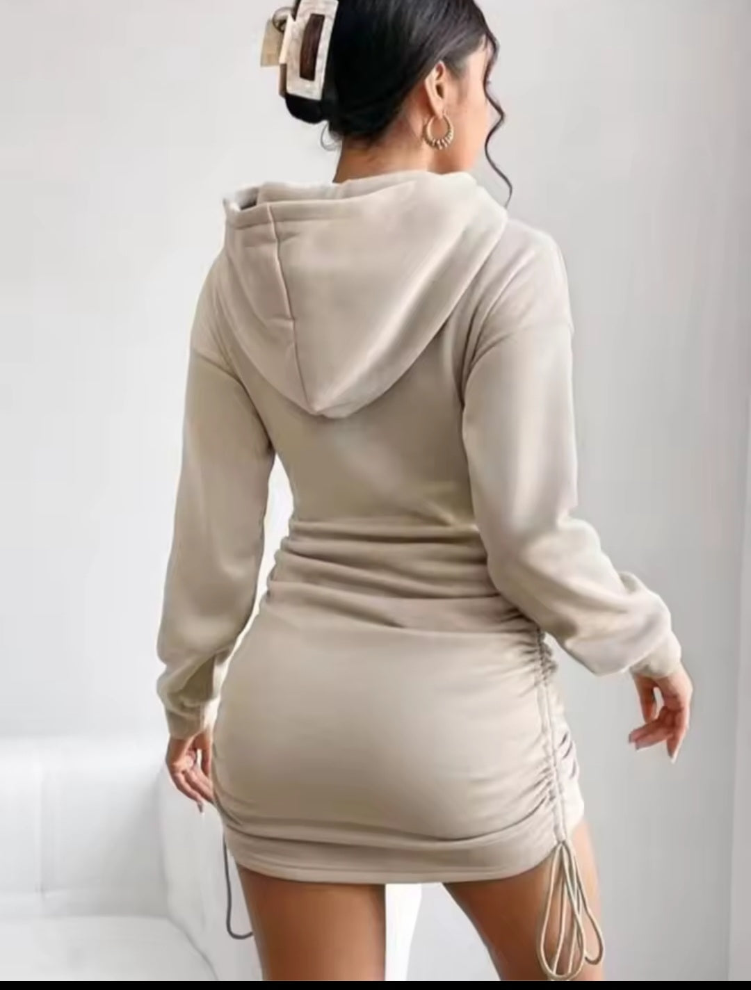 Beige hooded dress worn by a person on a white background