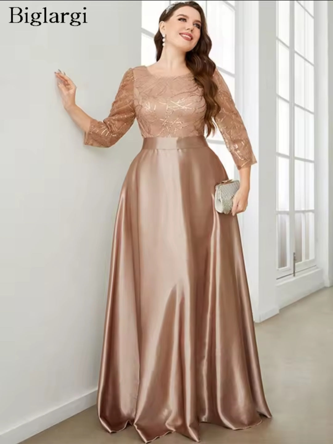 Woman wearing a long, elegant dress with lace sleeves in a bright room.