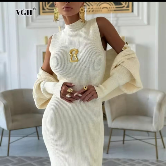 Woman wearing a cream-colored dress with gold accents in an elegant room.