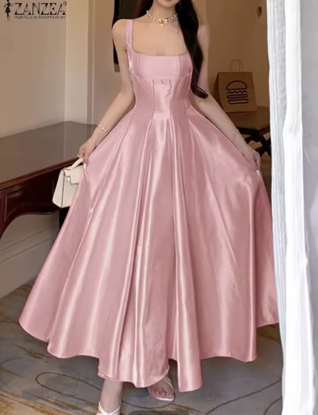 Woman wearing a pink satin dress in an indoor setting