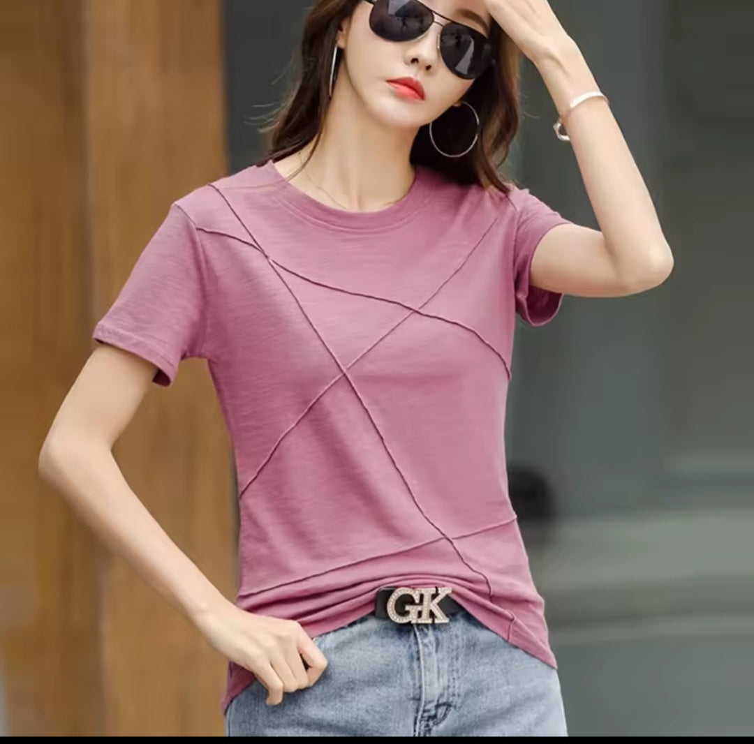 Woman wearing a pink t-shirt and sunglasses with a blurred background