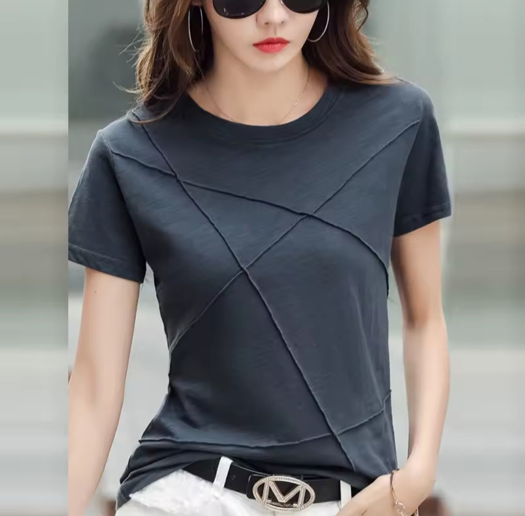 Woman wearing a dark gray t-shirt with a blurred background