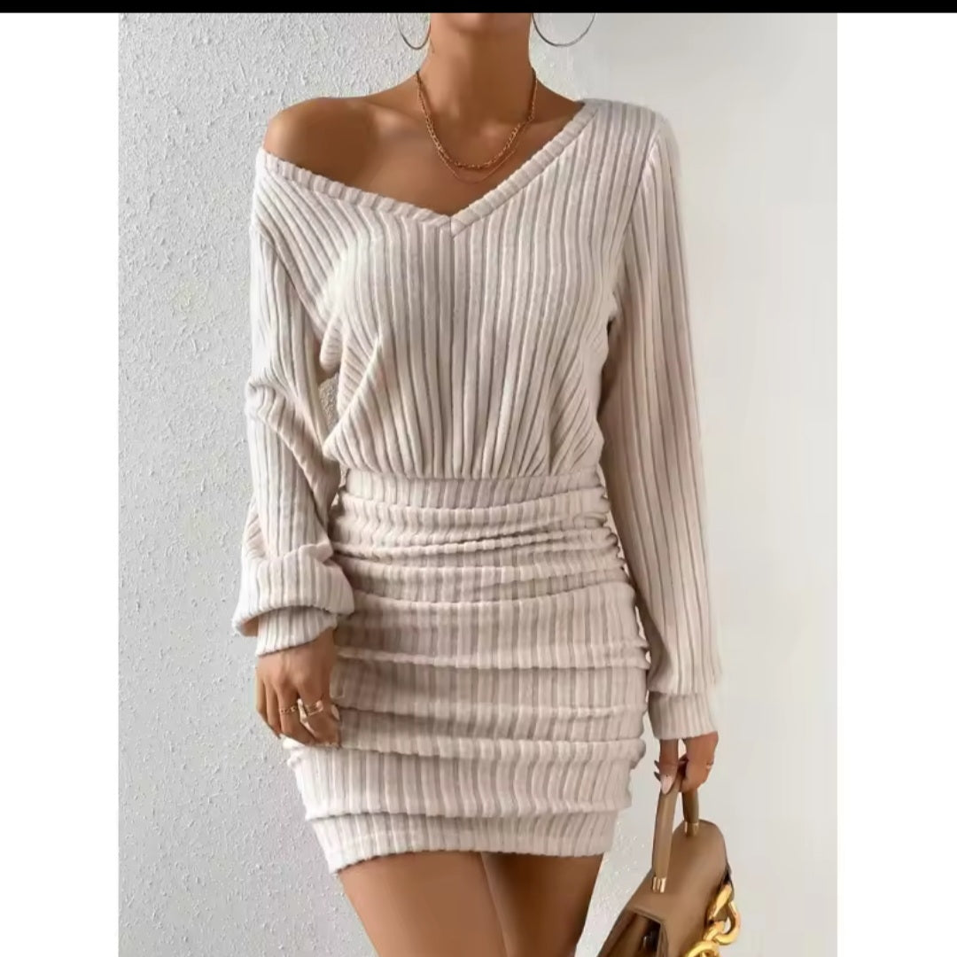 Woman wearing a ribbed knit dress against a plain background