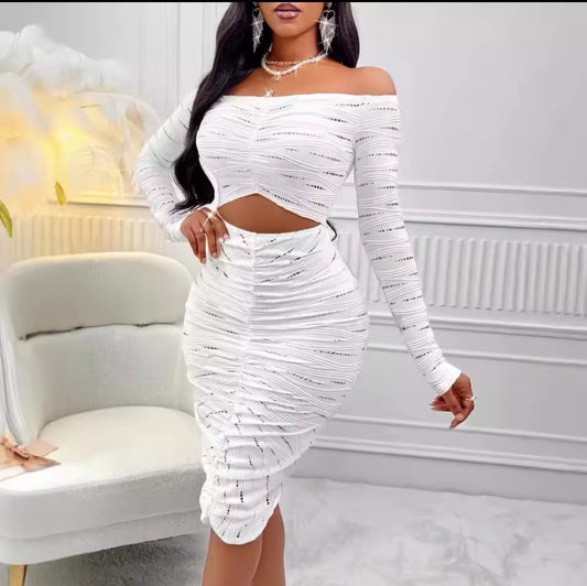 Woman wearing a white off-shoulder dress in an elegant room.