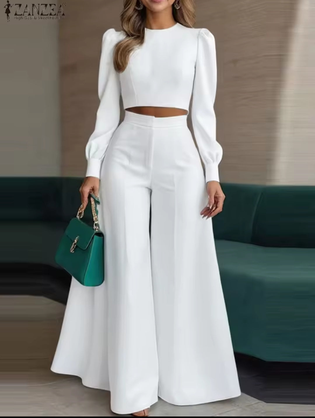 Woman in a white outfit holding a green handbag in an indoor setting
