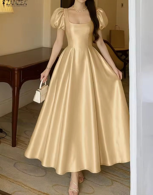 Woman wearing a gold satin dress in an indoor setting