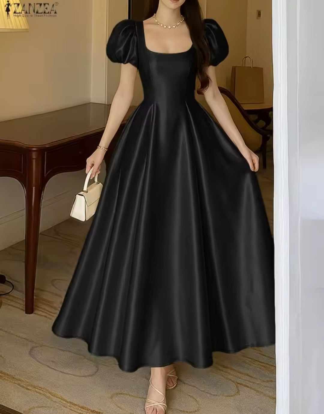 Woman wearing a black satin dress in an indoor setting