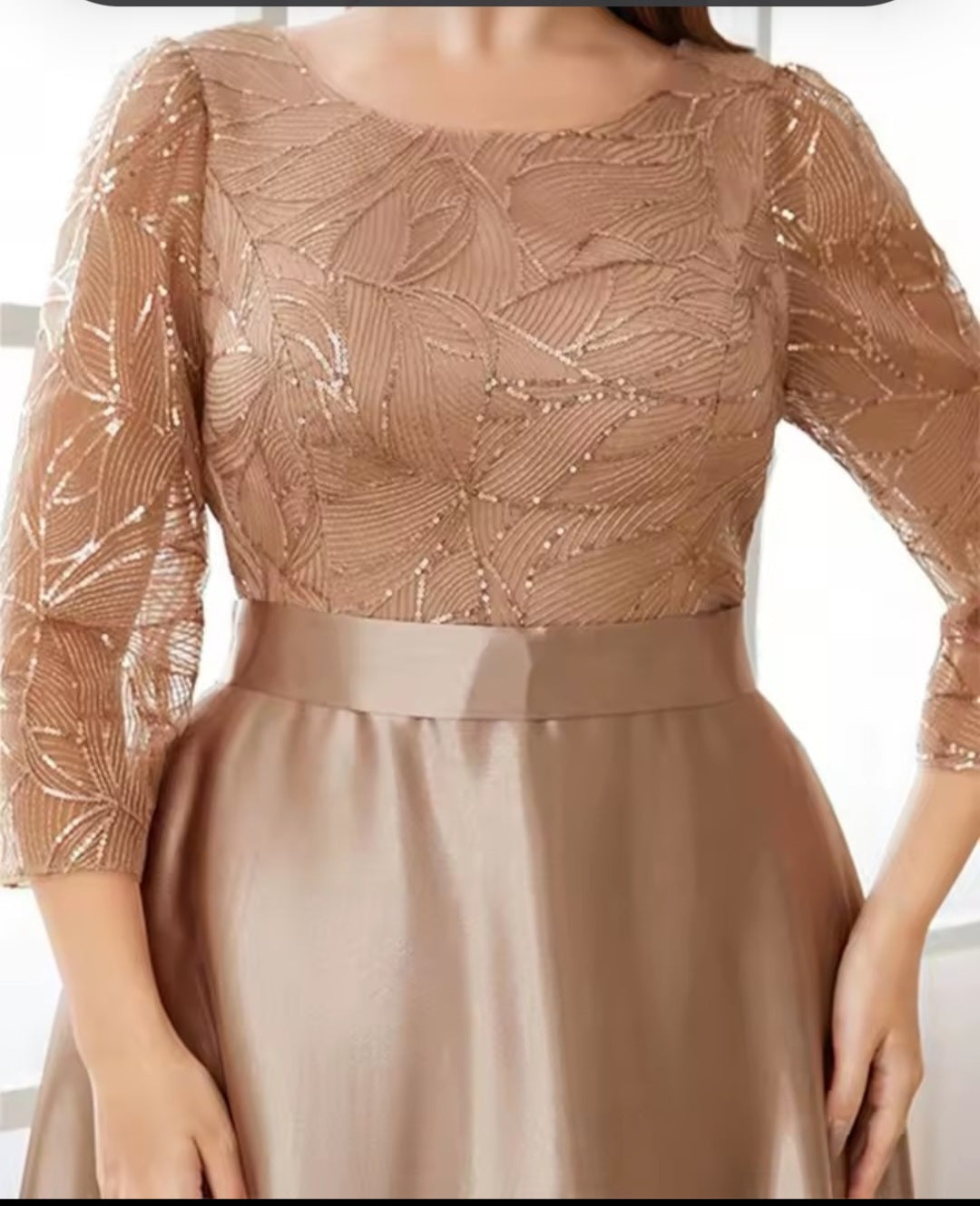 Beige dress with a patterned top and plain skirt on a neutral background