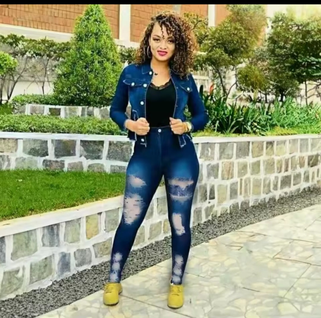 Woman wearing a blue denim outfit with a black top, standing outdoors.