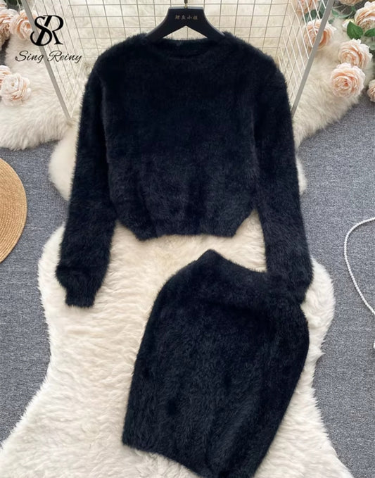 Black textured sweater and skirt set on a white surface with 'Sing Reiny' branding.