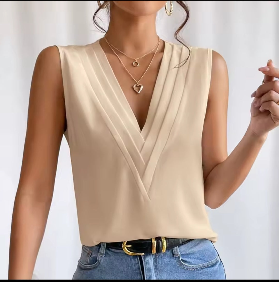 Beige sleeveless top worn by a person on a plain background