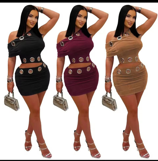 Three women wearing different colored two-piece outfits with metallic accents on a white background.