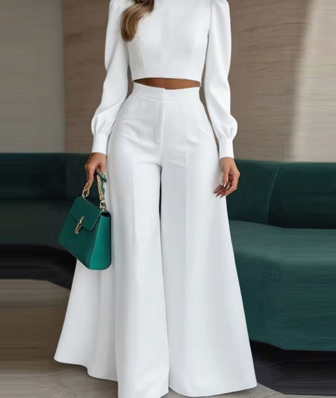 Person wearing a white outfit with a green handbag in an indoor setting