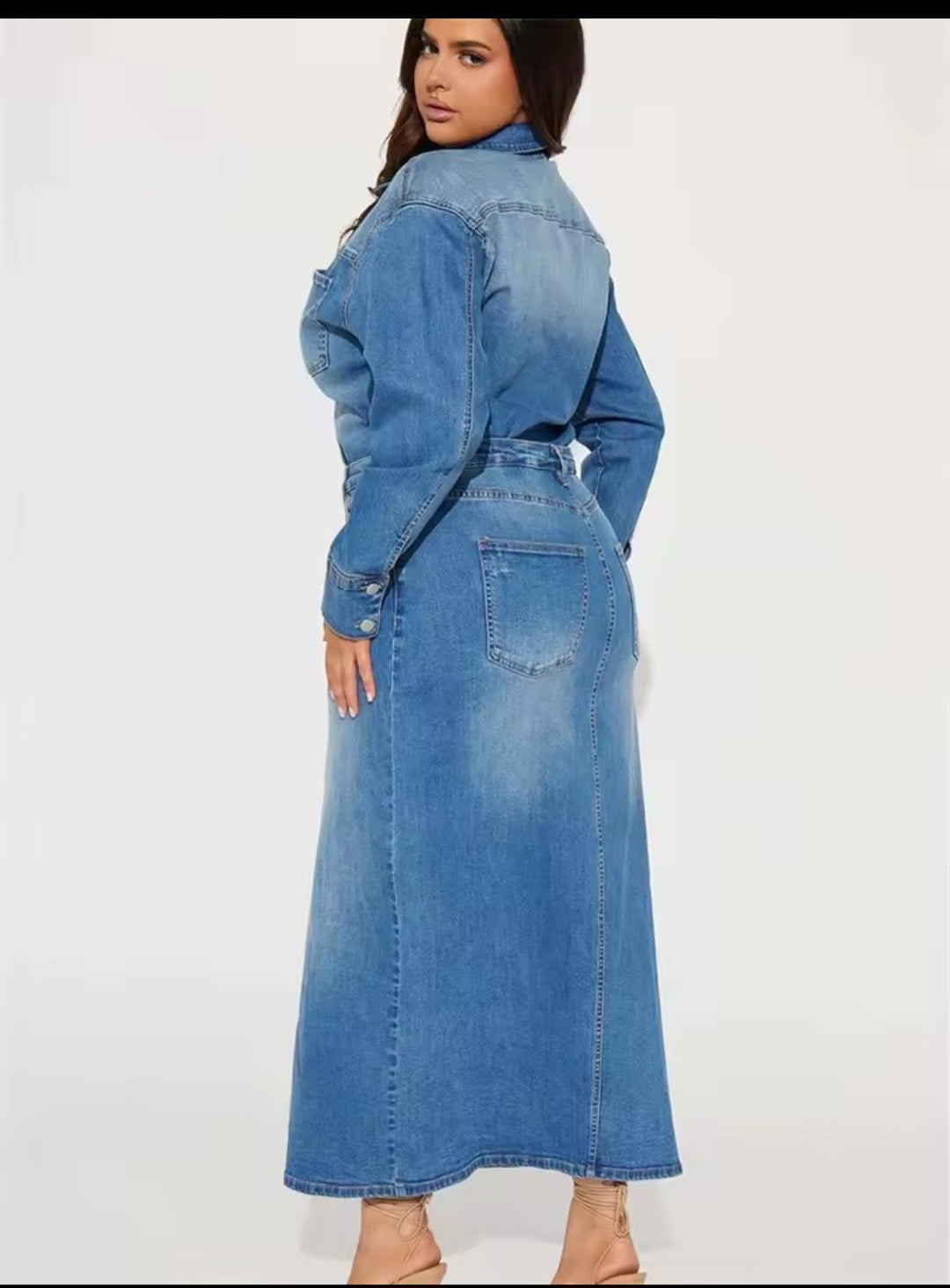 Woman wearing a long denim dress on a white background