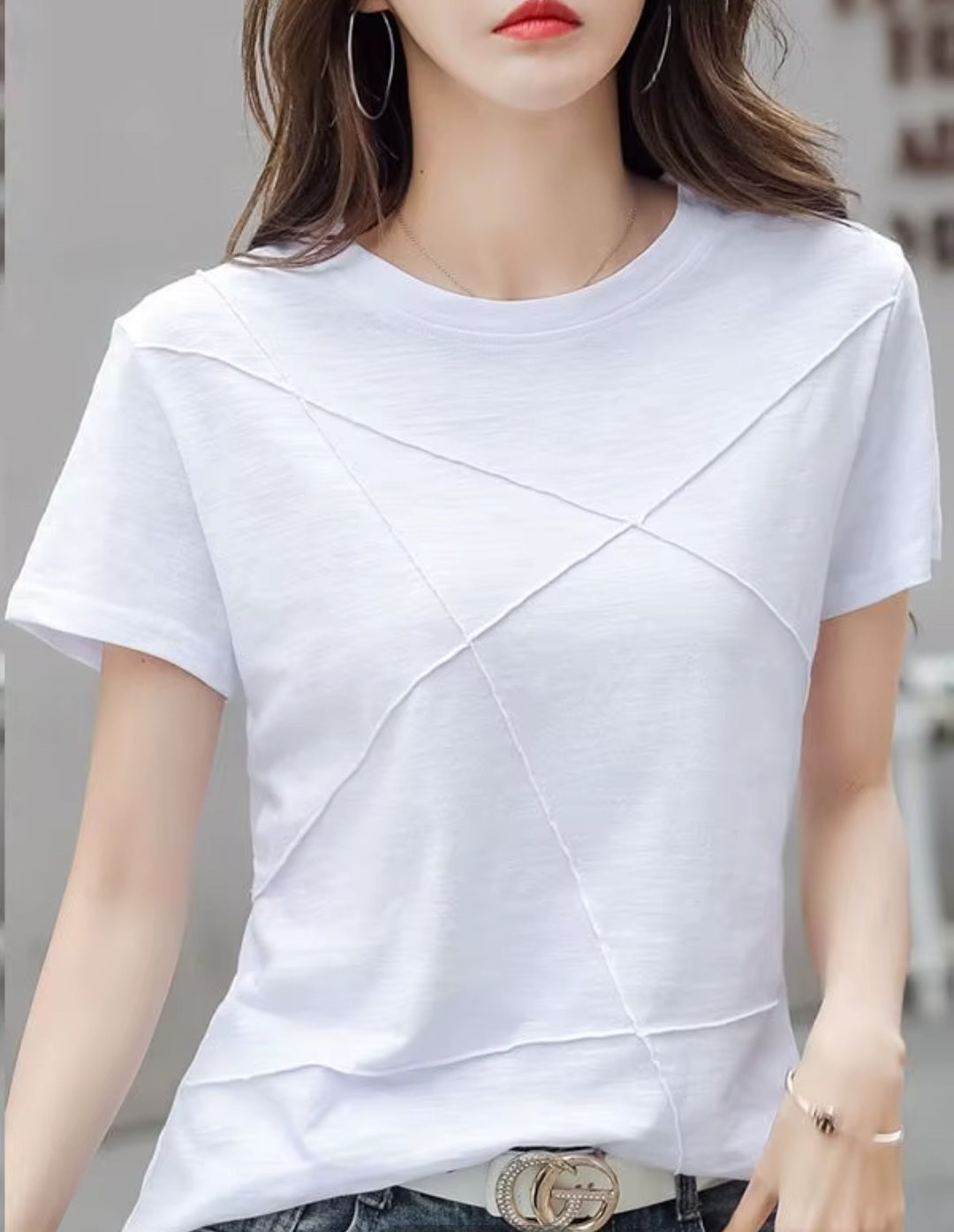 White t-shirt worn by a person with a blurred background