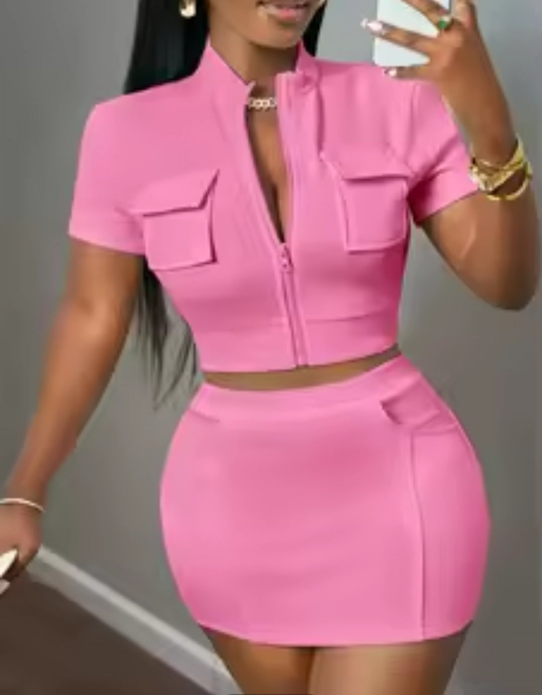 Woman wearing a pink two-piece outfit against a neutral background