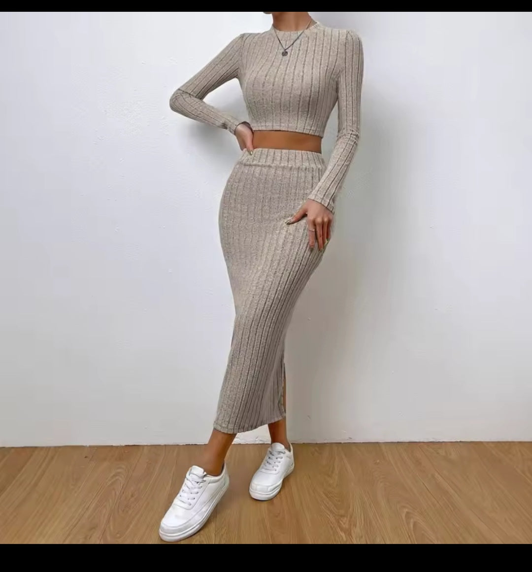 Person wearing a beige ribbed two-piece outfit with white sneakers on a plain background