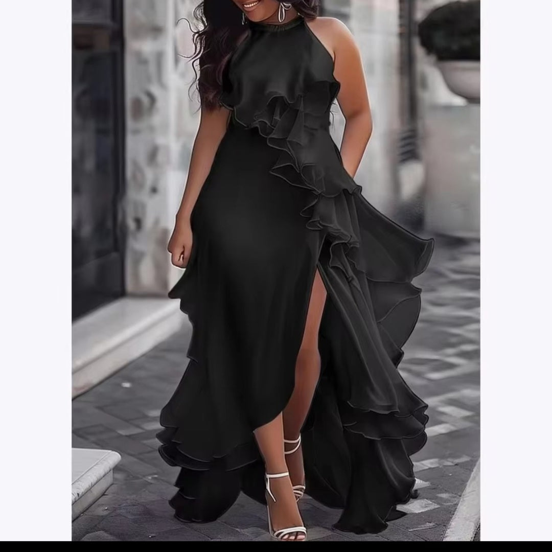 Woman wearing a black ruffled dress with a high slit on a blurred street background