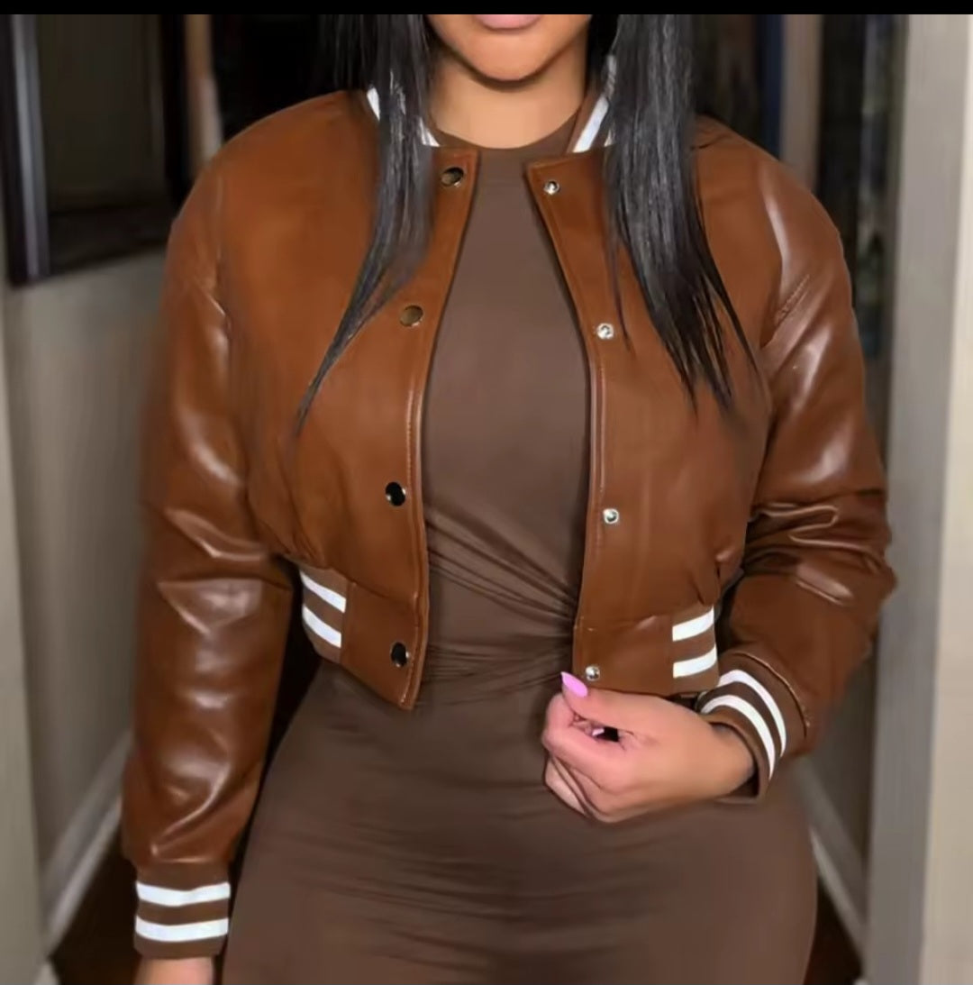 Person wearing a brown leather jacket with white stripes on the sleeves.