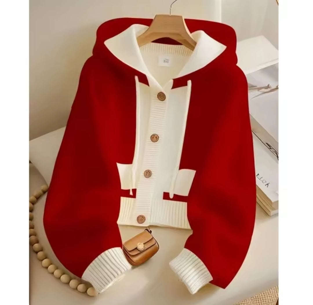Red and white cardigan with a small brown bag on a white surface