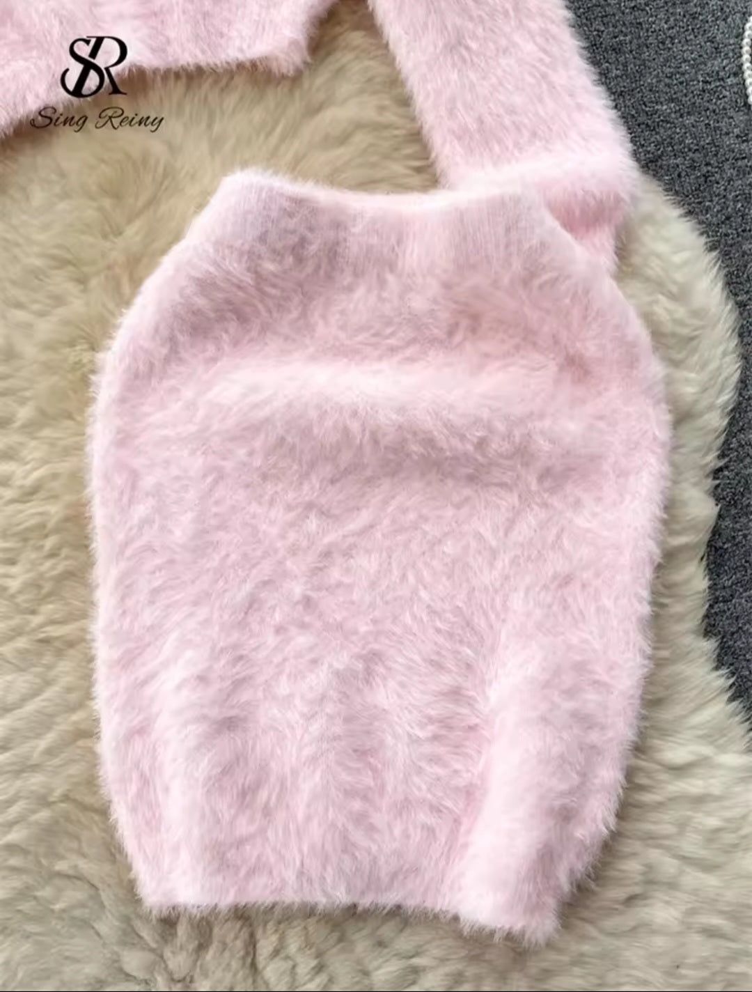 Pink fluffy dog coat on a textured surface