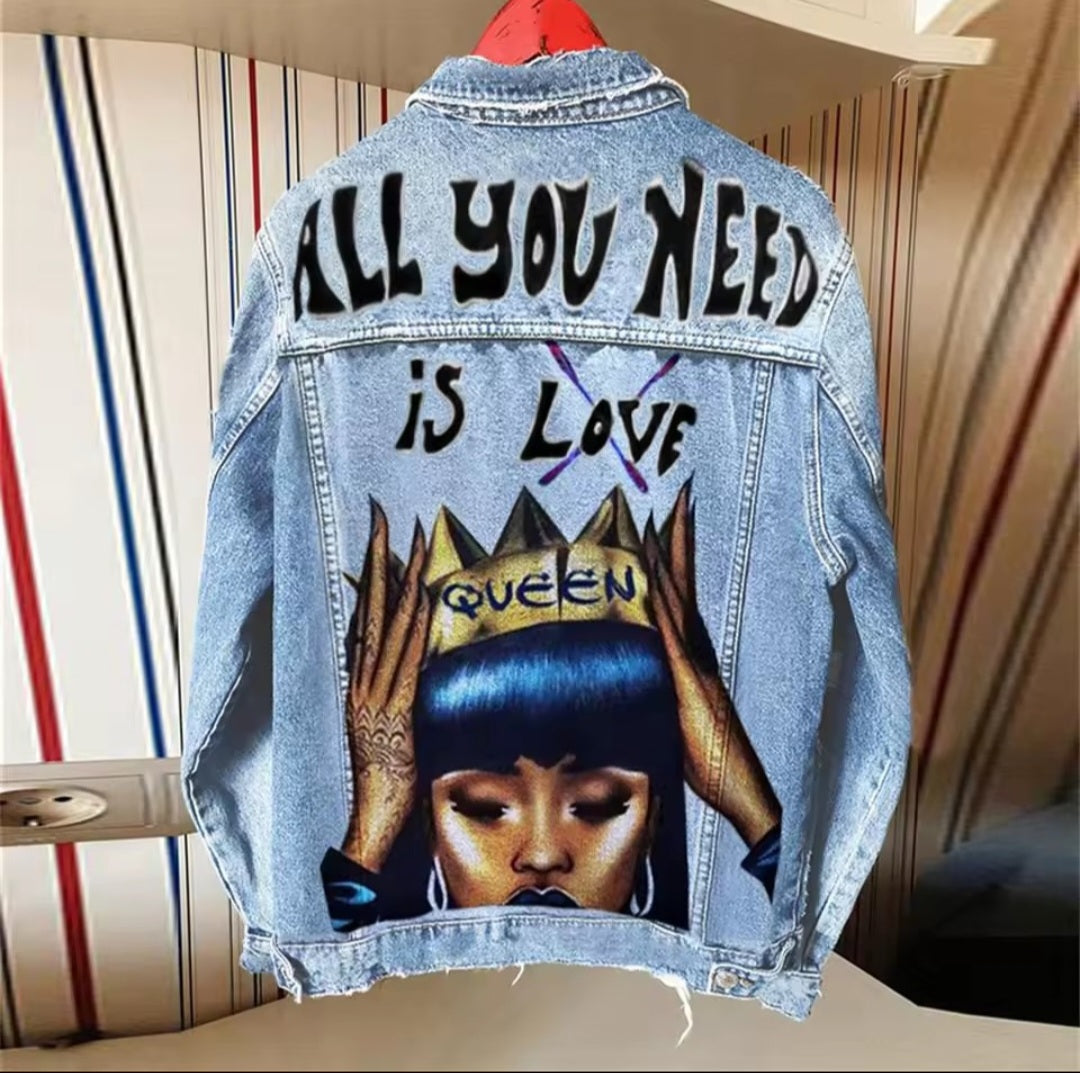Denim jacket with graphic design and text 'All you need is love queen' on a striped background
