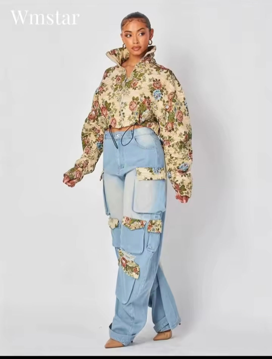 Person wearing a floral hoodie and patchwork jeans on a white background