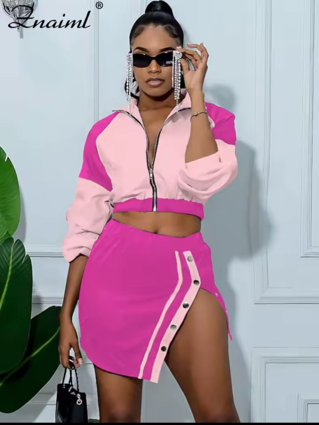 Woman wearing a pink and purple outfit with a brand logo in the corner.