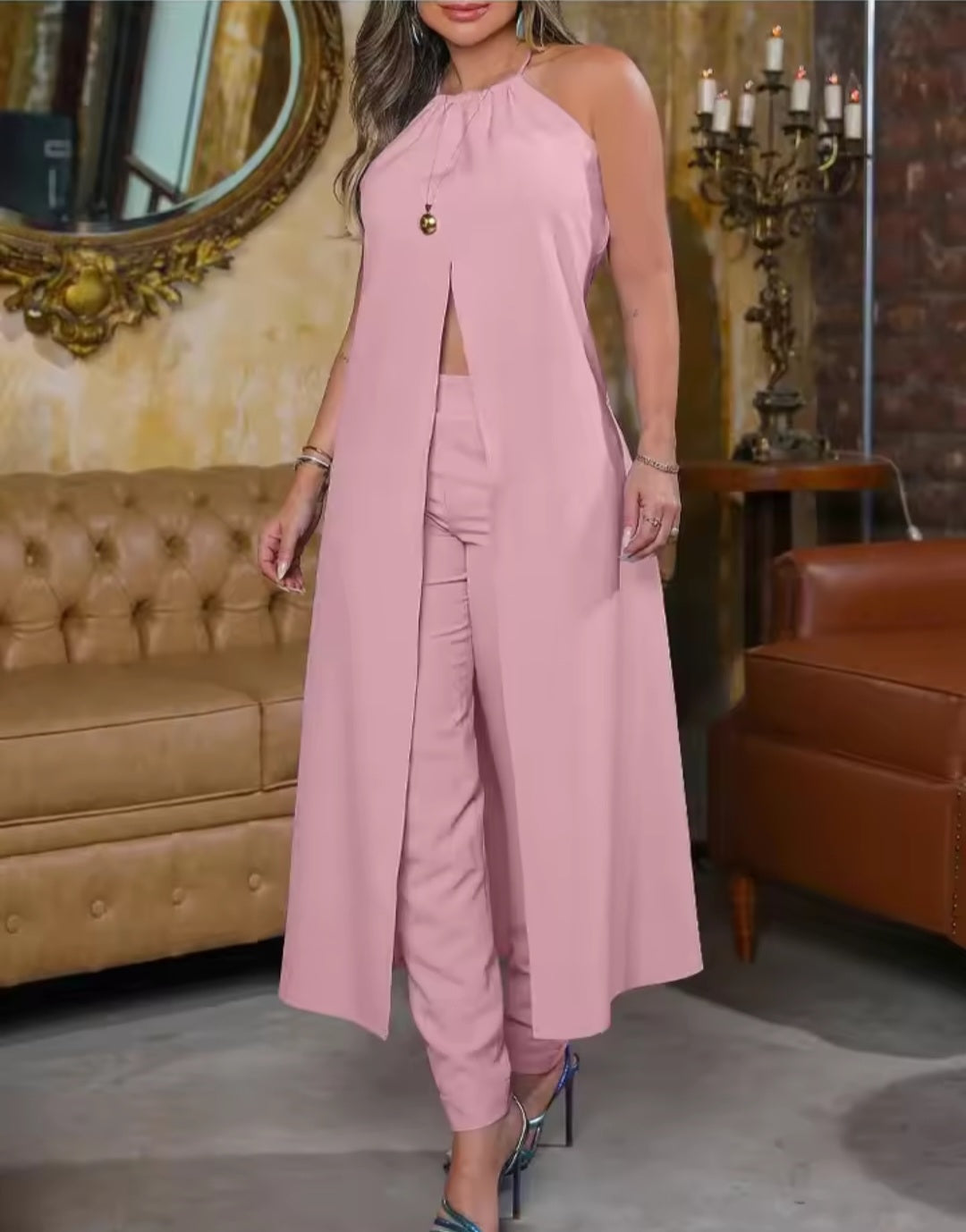 Woman in a pink outfit standing in a room with a mirror and furniture.