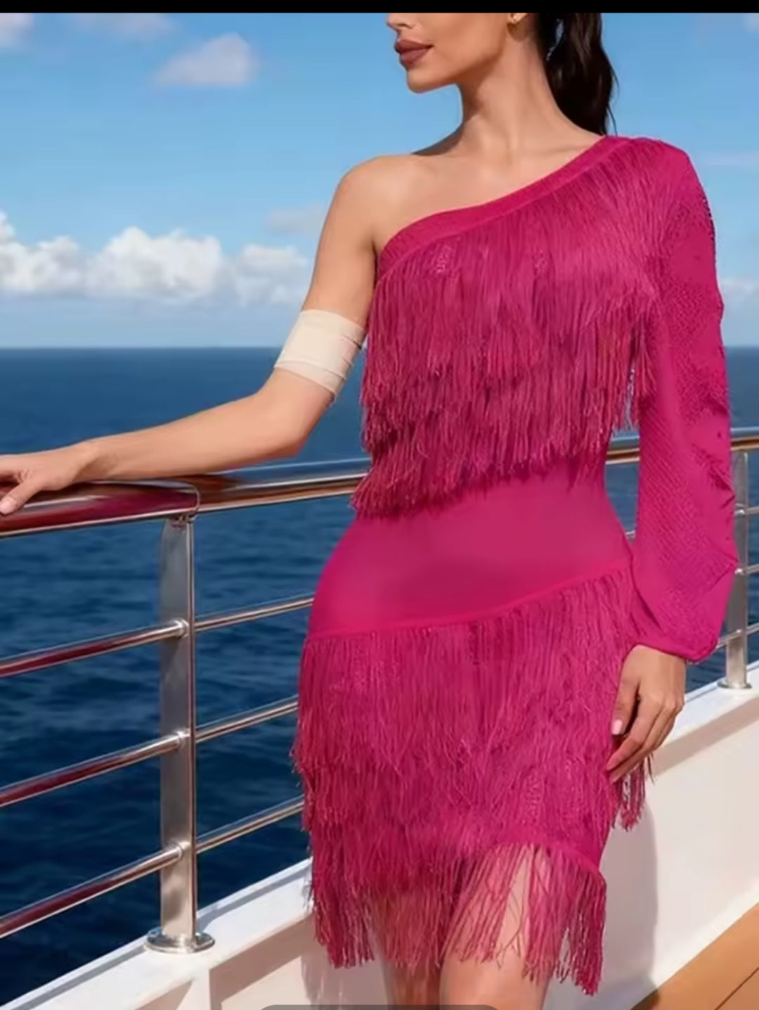 Woman in a pink fringe dress on a boat with ocean and sky background