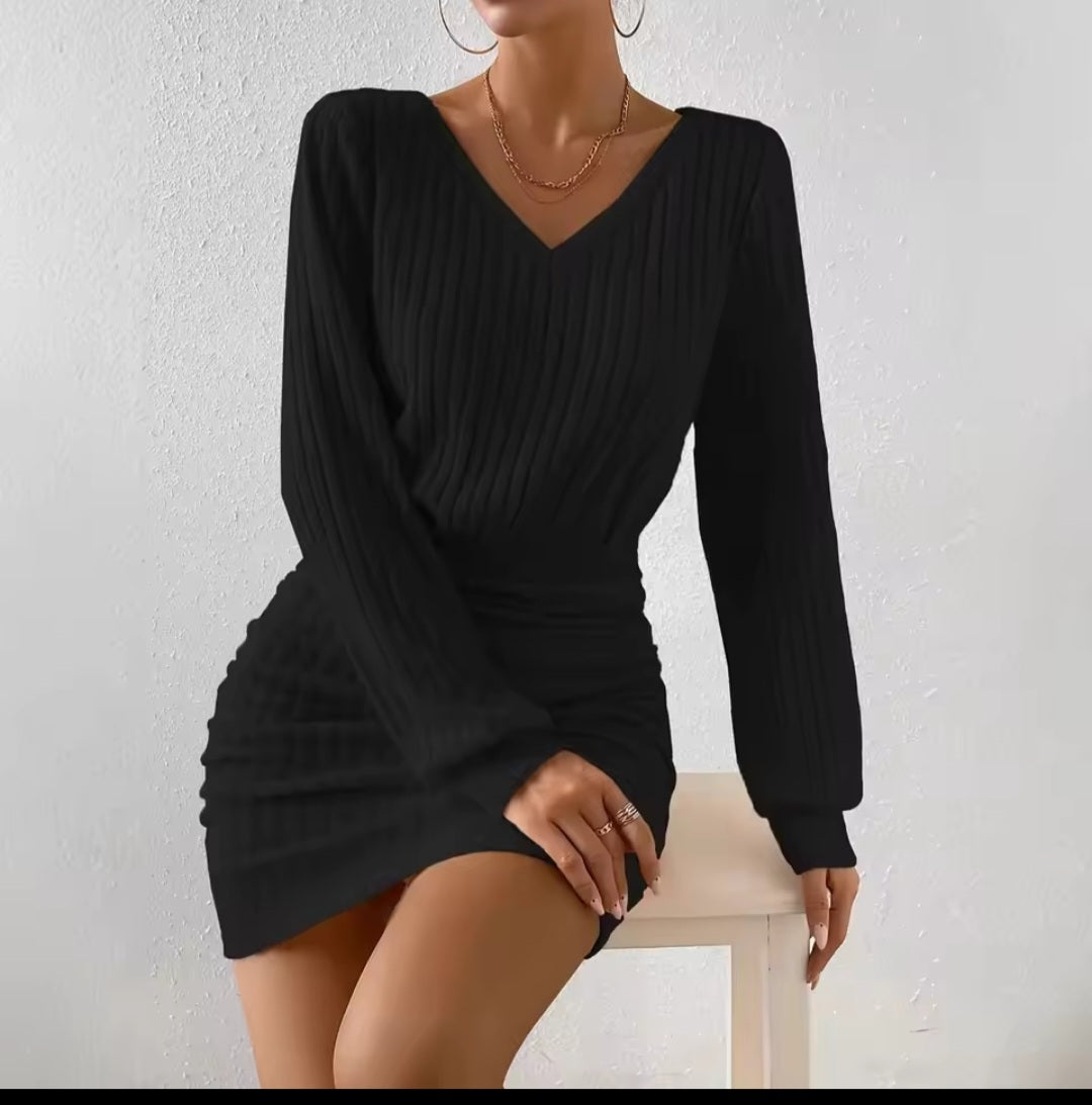 Black long-sleeve dress worn by a person on a white background