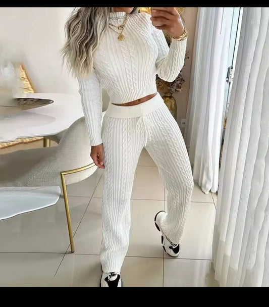 Person wearing a white ribbed knit outfit in a modern room.